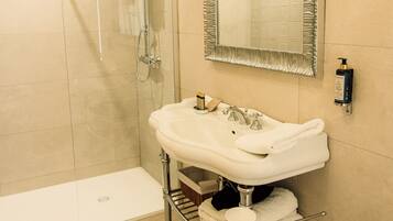 Un bagno con doccia vetrata, un mobile lavabo con specchio e un water.