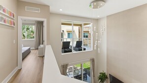 A modern interior with a staircase, a balcony with outdoor seating, and a large window. - Designer 4BR Getaway, Sleek Laminate Floors (Kissimmee)