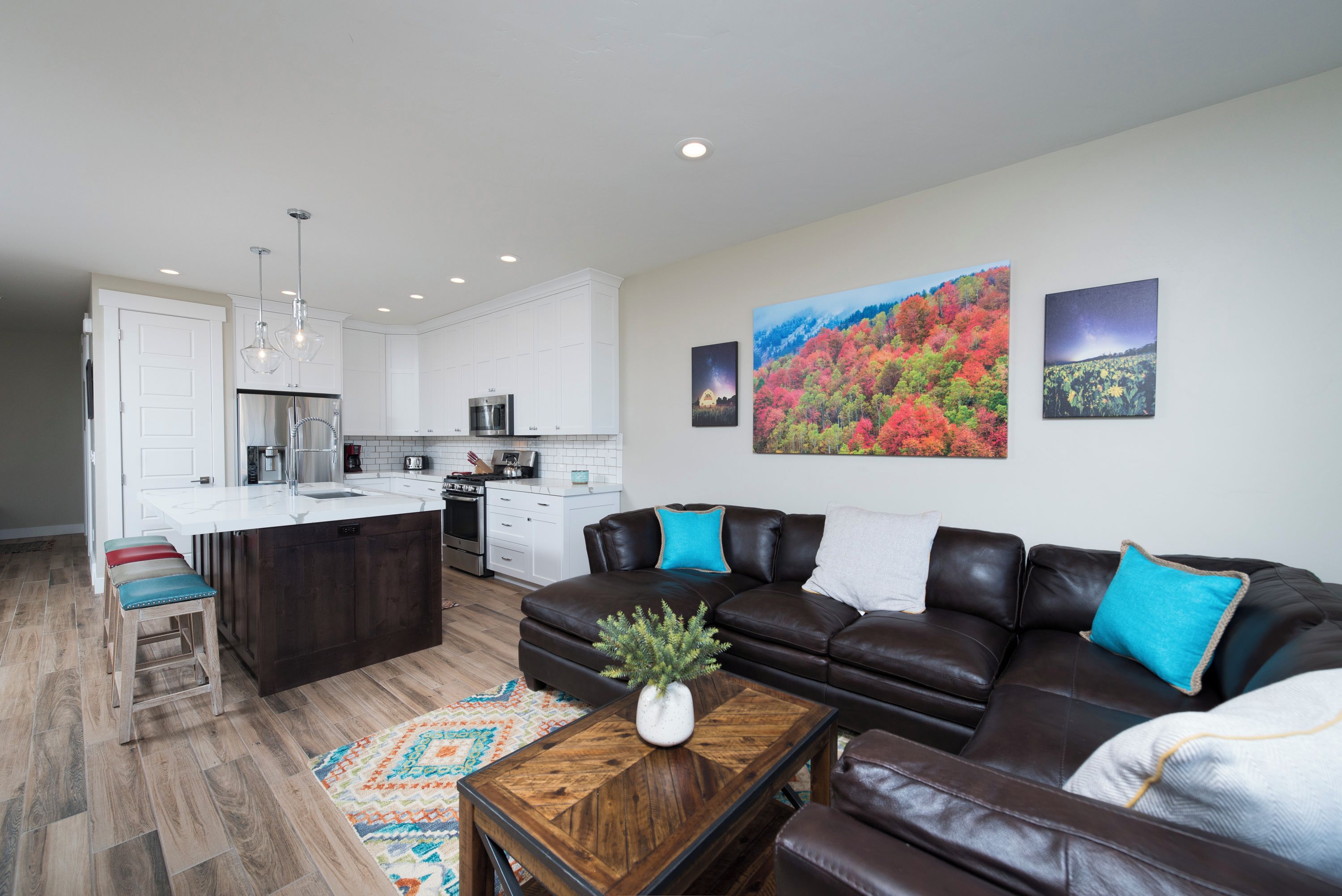 A modern kitchen with white cabinets, a central island, and stainless steel appliances.