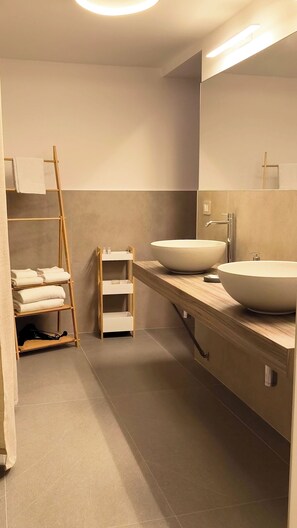 A modern bathroom with a large sink, a mirror, a towel rack, and a shelf. - B&B Sicily Luxury  (Catania)