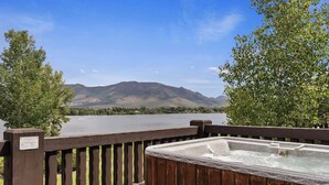 A hot tub on a wooden deck with a view of a lake and mountains. - Lakefront Luxury Retreat LS61 | Hot Tub | Pool (Huntsville)