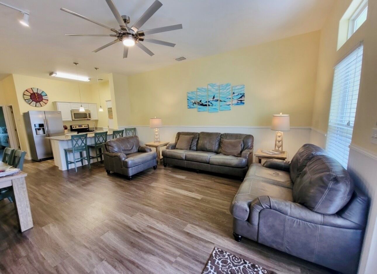 A living room with a sofa, a coffee table, and a dining area with chairs and a table.