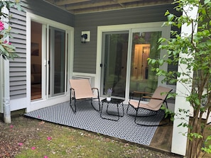 A patio with two chairs, a small table, and a potted plant.