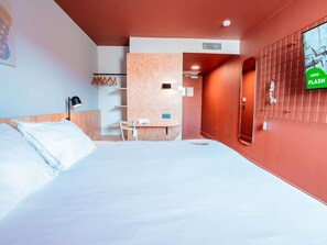 A hotel room with a bed, a desk, a chair, a TV, and a wardrobe. - Greet Hotel Montpellier Aéroport Parc des Expos (Mauguio)