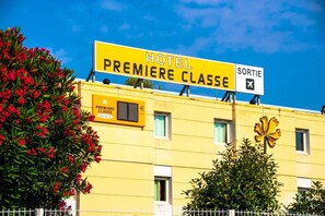 Ein Hotelschild mit der Aufschrift 'HOTEL PREMIERE CLASSE' und einem 'SORTIE'-Schild, das einen Ausgang kennzeichnet.