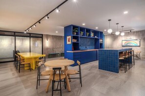 A modern interior with a yellow table, blue cabinets, and a bar area. - Amplio y tranquilo departamento a pasos de Reforma (Mexico City)