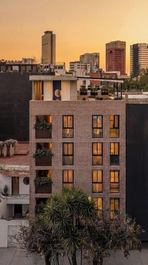 A multi-story building with balconies, large windows, and a city skyline in the background. - Amplio y tranquilo departamento a pasos de Reforma (Mexico City)