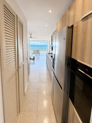 Eine Küche mit Kühlschrank, Backofen und Blick auf den Ozean.
