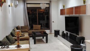 Ein modernes Wohnzimmer mit Sofa, Couchtisch, Fernseher und Dekoration.