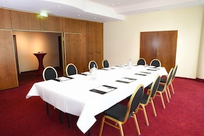 A conference room with a long table, chairs, and a red carpet. - Lindner Congress Hotel (Cottbus)