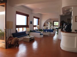 Amplia sala de estar con sofá, mesa de centro y una encimera blanca curva.
