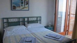 A bedroom with a bed, a nightstand, and a window. - Hotel Phenicusa (Lipari)
