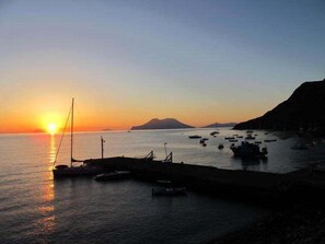 A coastal sunset with boats at a harbor. - Hotel Phenicusa (Lipari)