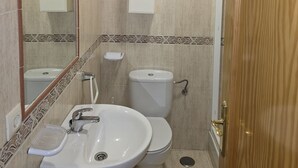 A bathroom with a sink, toilet, mirror, and a cabinet. - Hostal La Cigüeña (El Espinar)