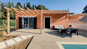 Eine moderne Außenpatio mit einer Pergola, einem Pool und einem Sitzbereich mit Tisch und Stühlen.