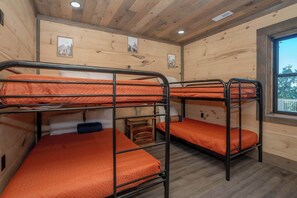 A bunk room with wooden walls and a window. - Indoor Pool + Panoramic Views | 4BR Sleeps 12 (Sevierville)