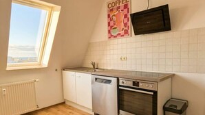 Keittiössä on ikkuna, astianpesukone, uuni, mikroaaltouuni ja laatoitettu välitila.