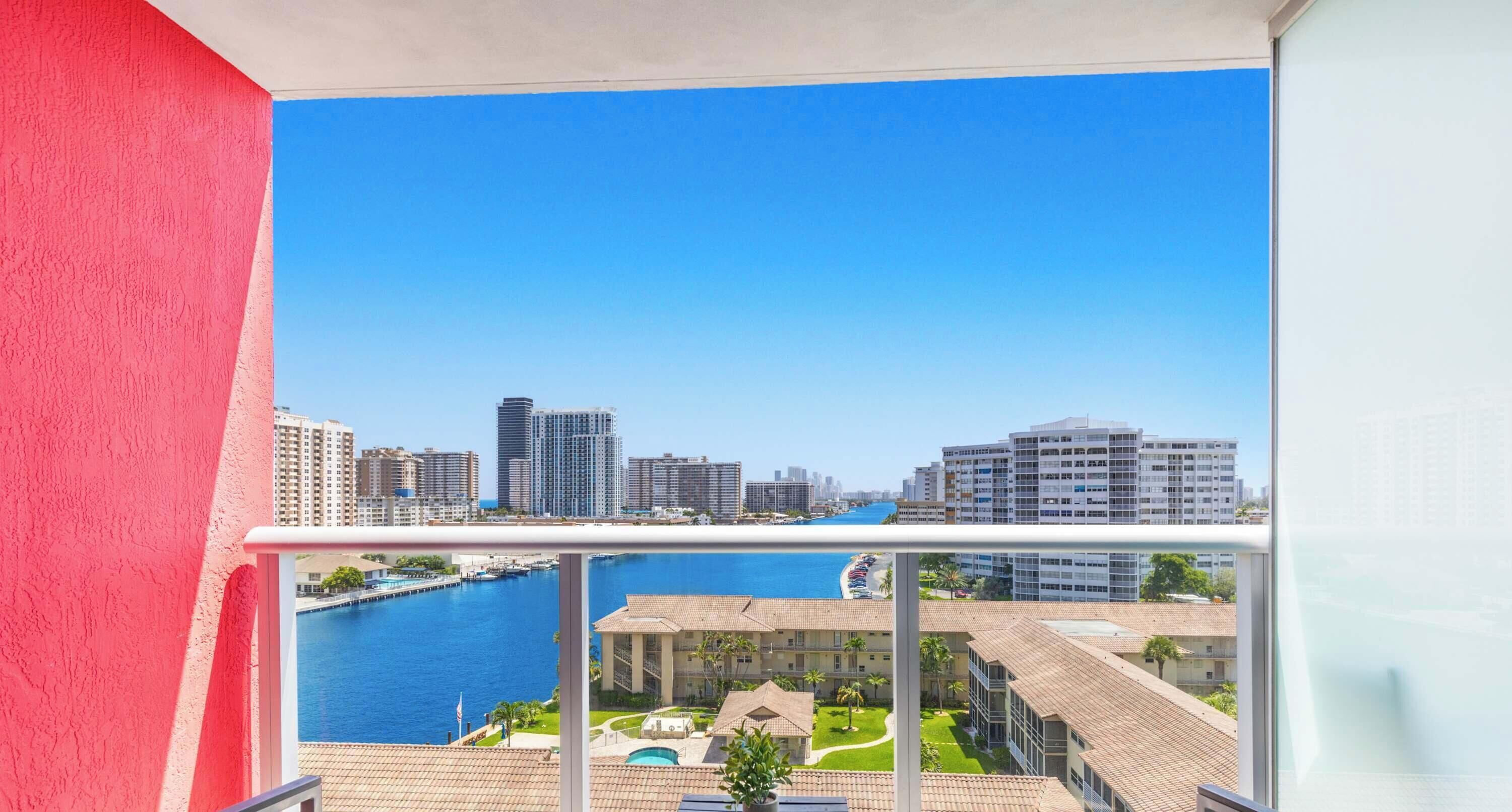 A high-rise building with a view of a marina and city skyline.