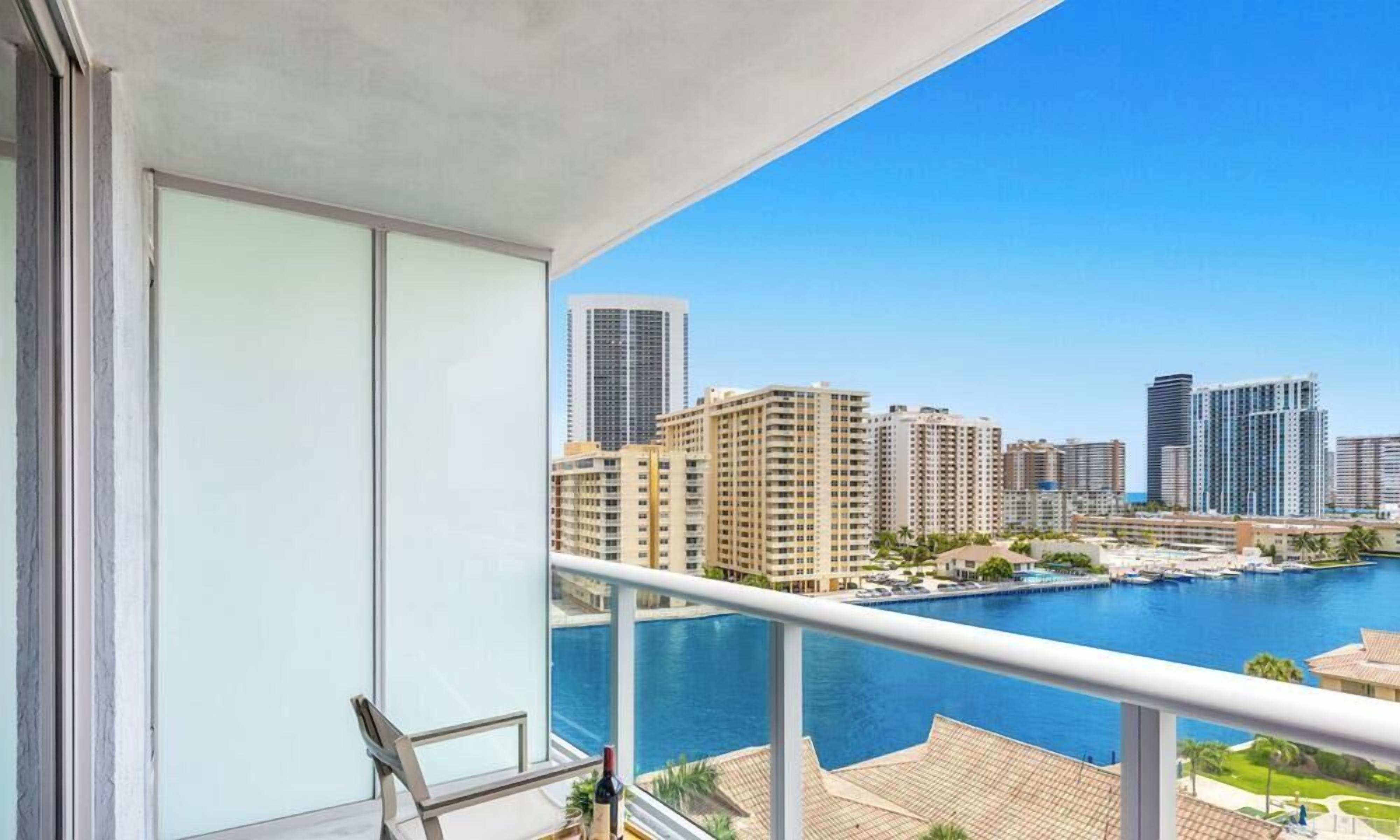 A balcony with a view of a marina and high-rise buildings.