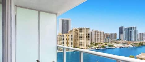 Ein Balkon mit Blick auf einen Yachthafen und hohe Gebäude.