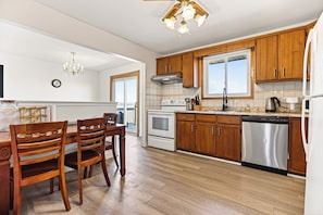 A kitchen with wooden cabinets, a stainless steel dishwasher, and a double oven.