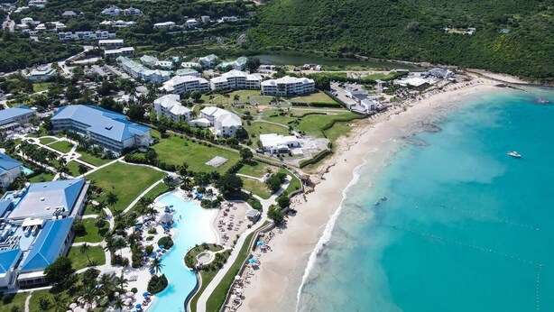An aerial view of a resort with a beach, swimming pool, and multiple buildings. - FIDEMAM (Anse Marcel)