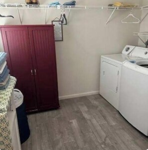 A laundry room with a red wardrobe, a washing machine, and a drying rack. - LAKEHOUSE, with dock in backyard. Premier Treasure Island area, 3 bedroom w AC. (Okeechobee)