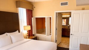 A hotel room with a bed, bedside lamp, and an open door leading to a bathroom and kitchen area. - Apt Resort 3br, Sleeps 10 Disney 10 min (Orlando)