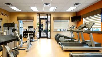 A gym with treadmills, elliptical machines, and weight equipment.