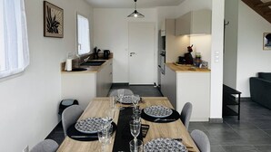 Een moderne keuken met een eethoek, een trap en uitzicht op buiten.