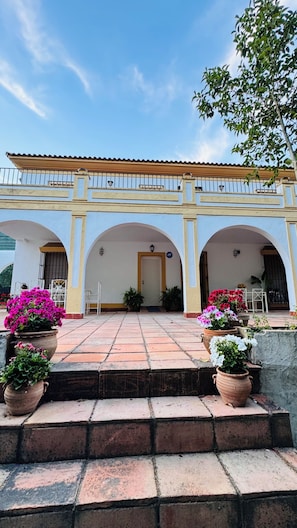 A building with a tiled patio, arches, and potted plants. - Casa Sevilla-Giralda, a villa with a pool just a few minutes from downtown Seville (Mairena del Aljarafe)