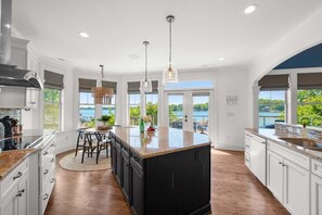 A modern kitchen with a large island, white cabinetry, and a view of a lake. - Kiser Island w/Optional Boat Rental & Game Room (Terrell)