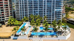 A hotel with a large pool area, multiple levels of balconies, and a view of the surrounding landscape. - Ocean-view 1BR condo in Puerto Vallarta with pool, gym and balcony. (Puerto Vallarta)