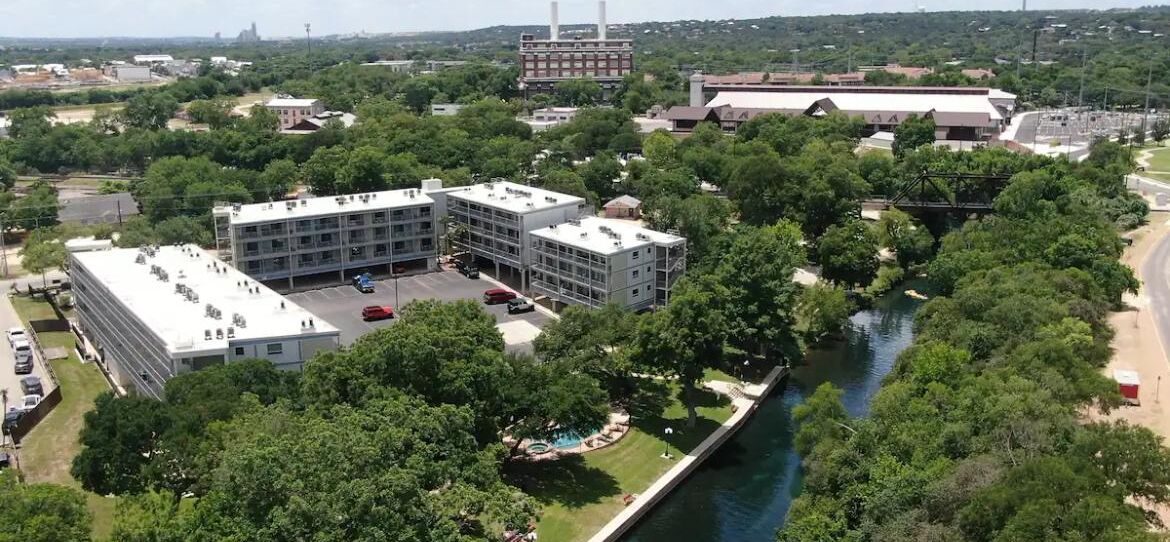 An industrial area with multiple buildings, a river, and a bridge.
