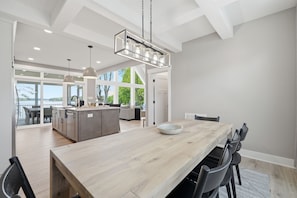 A spacious kitchen with a large island, pendant lighting, and a view to the outdoors.