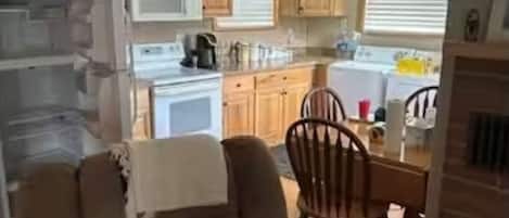 Une cuisine avec des meubles en bois, un four à micro-ondes et un coin repas comprenant une table et des chaises.