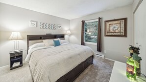 A bedroom with a bed, nightstands, a window with curtains, and wall art. - Quaint Stillwater Retreat Minutes from Historic Downtown - Lilac Apartment (Stillwater)