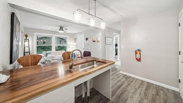 A modern kitchen with a wooden countertop, stainless steel sink, and pendant lighting. - Accessible 3-Bedroom Retreat Near Historic Downtown Stillwater - Morning Glory (Stillwater)