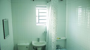 Un baño con inodoro, lavamanos y bañera.
