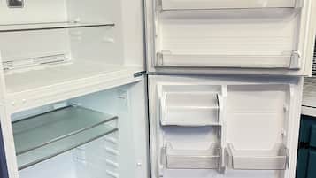 Et åbent køleskab med flere hylder og skuffer, et kontrolpanel og en vanddispenser.