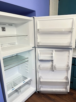 An open refrigerator with multiple shelves and drawers, a control panel, and a water dispenser.