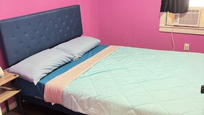 A room with a bed, a window with a black curtain, and a wall heater. - Pet friendly Brand new home in Central Oklahoma City (Oklahoma City)
