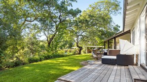 A wooden deck with outdoor furniture, a covered seating area, and a well-maintained lawn. - Oak and Stone | Pool + Glen Ellen Wine Country (Glen Ellen)