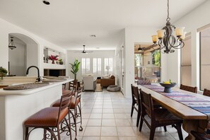 A spacious kitchen with a dining area, a bar, and a ceiling fan. - Golf Course Desert Retreat with Private Patio (Scottsdale)