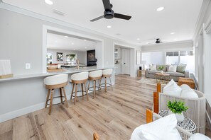 Eine moderne Küche mit Barbereich, Holzboden und Deckenventilator.
