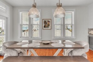 A dining area with a long table, two pendant lights, and a framed picture on the wall. - Casa Solmar (Treasure Island)