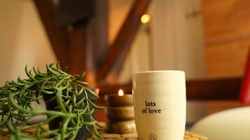 Una candela con la scritta 'lots of love', una pianta in vaso e un candeliere su un tavolo.