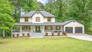 A two-story house with a front porch, garage, and a well-maintained lawn.