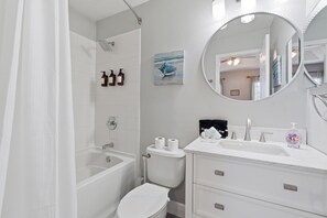 Un baño con bañera, inodoro, lavabo y espejo.