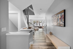 Ein modernes Interieur mit Treppe, einer Sitzbank und einem Gemälde an der Wand.